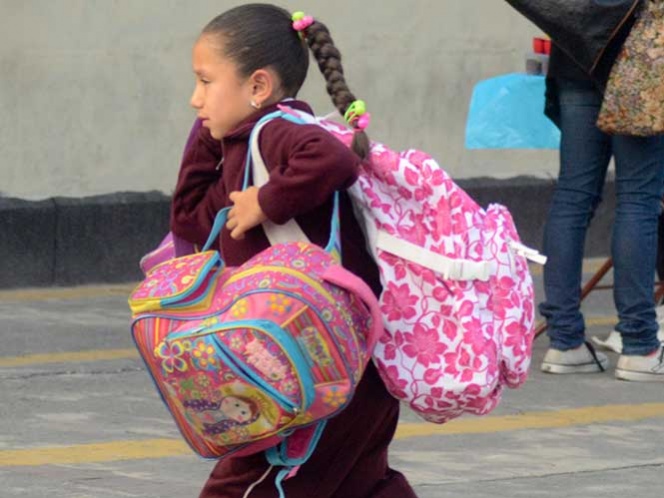 Peso de mochila escolar afecta columna de niños