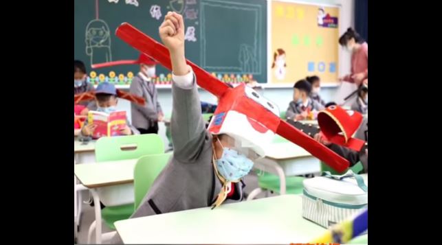 alumnos chinos regresan a clases con extraños sombreros