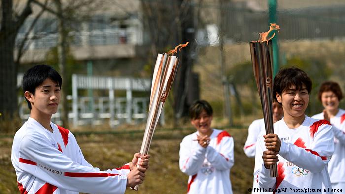 mujer-intenta-apagar-antorcha-olimpica-con-pistola-de-agua-tokio-2020-jpg